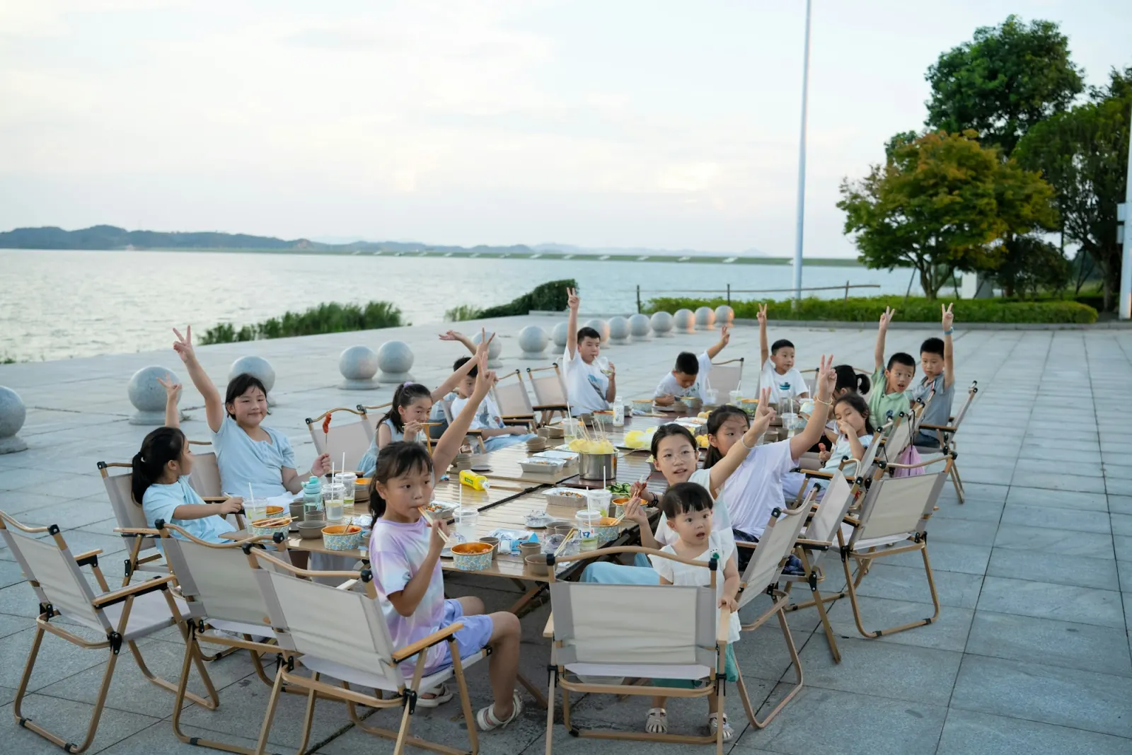 孩子們在水岸邊開心舉手
